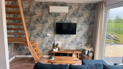 a living room with a couch and a tv on a wall at Riwiera Strzelecka in Strzelce Małe