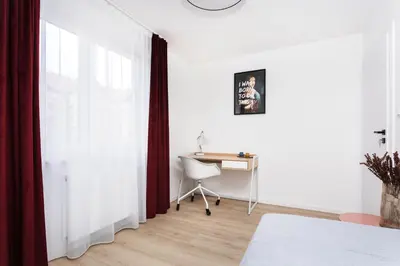 a white room with a desk and a window at SOL Apartment in Kraków
