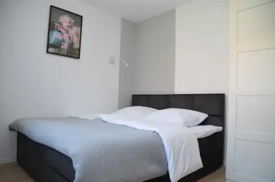 a bedroom with a bed with white sheets and pillows at SOL Apartment in Kraków