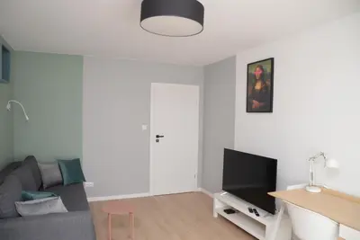 a living room with a couch and a flat screen tv at SOL Apartment in Kraków