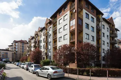 a row of cars parked in front of a building at SOL Apartment in Kraków