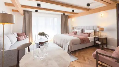 a hotel room with a bed and a couch and a table at Avanti Villa in Kraków