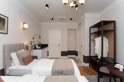 a bedroom with two beds and a mirror at Avanti Villa in Kraków
