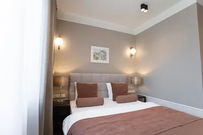 a bedroom with a large white bed with brown pillows at Avanti Villa in Kraków