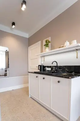 a kitchen with white cabinets and a sink at Avanti Villa in Kraków