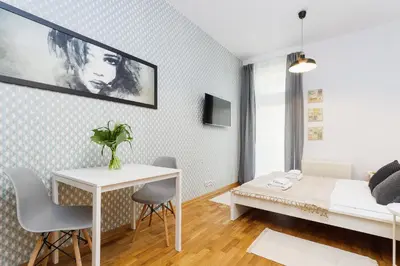 a bedroom with a bed and a desk and a table at Apartment with balcony - Rzeszowska 4 Street in Kraków