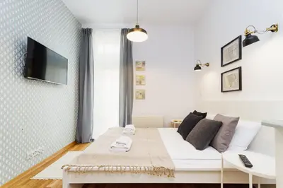 a living room with a couch and a tv on a wall at Apartment with balcony - Rzeszowska 4 Street in Kraków