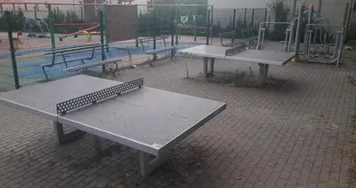 two picnic tables in a park with a playground at Apartamenty Kraków-Bielany in Kraków