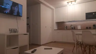 a living room with a tv and a kitchen at Apartamenty Kraków-Bielany in Kraków