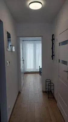 an empty room with a hallway with a large window at Apartamenty Kraków-Bielany in Kraków