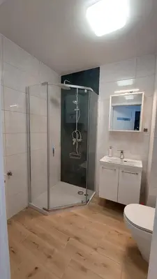 a bathroom with a shower and a toilet and a sink at Apartamenty Kraków-Bielany in Kraków