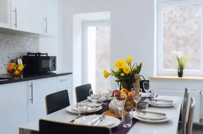 a dining room table with glasses and flowers on it at Apartment with balcony - 21 Filipa Street in Kraków