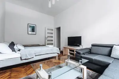 a living room with a couch and a tv and a table at Apartment with balcony - 21 Filipa Street in Kraków