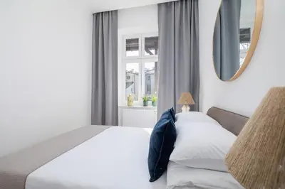 a bedroom with a bed and a mirror and a window at 4-Bedroom Apartment - Private Sauna - Wielopole 7 in Kraków