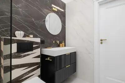 a black and white bathroom with a sink and a mirror at 4-Bedroom Apartment - Private Sauna - Wielopole 7 in Kraków