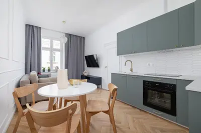 a kitchen with a white table and chairs in a kitchen at 4-Bedroom Apartment - Private Sauna - Wielopole 7 in Kraków