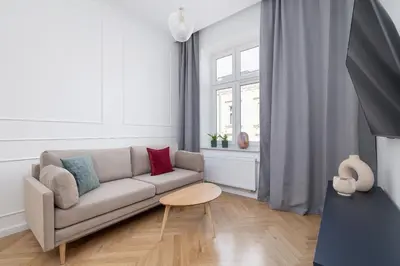 a white living room with a couch and a table at 4-Bedroom Apartment - Private Sauna - Wielopole 7 in Kraków