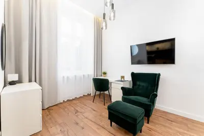 a living room with a chair and a desk at Józefińska Deluxe Studio by BookingHost in Kraków