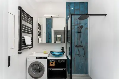 a bathroom with a washing machine and a shower at Józefińska Deluxe Studio by BookingHost in Kraków