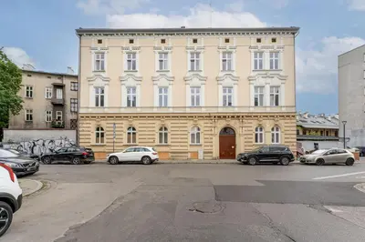 a large building with cars parked in front of it at Józefińska Deluxe Studio by BookingHost in Kraków