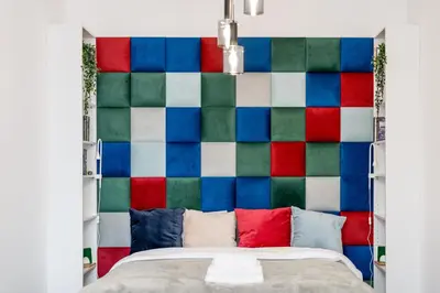 a bed with a colorful wall behind it at Józefińska Deluxe Studio by BookingHost in Kraków