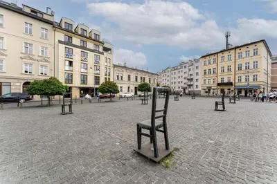 a chair in the middle of a street with buildings at Józefińska Deluxe Studio by BookingHost in Kraków