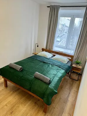 a bedroom with a large green bed with a window at Nice rooms in City Center Kraków in Kraków