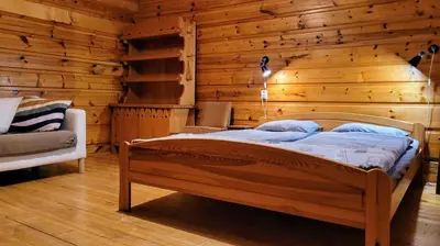 a bedroom with a bed in a wooden wall at Domek Abi in Rabka-Zdroj