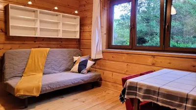 a room with a couch and a table in a cabin at Domek Abi in Rabka-Zdroj