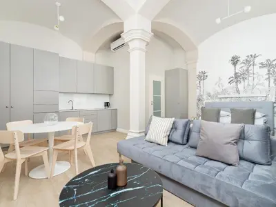 a living room with a blue couch and a table at Apartment - Main Square in Kraków