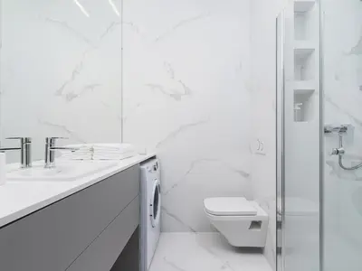 a white bathroom with a toilet and a shower at Apartment - Main Square in Kraków