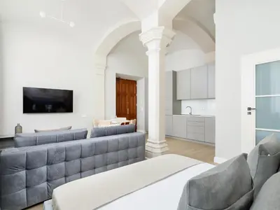 a living room with a couch and a kitchen at Apartment - Main Square in Kraków