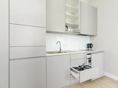 a kitchen with white cabinets and a sink at Apartment - Main Square in Kraków