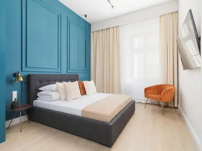 a bedroom with a bed with blue walls and a chair at Main square - Apartment with 2 bedrooms in Kraków