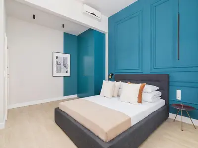 a bedroom with a bed with blue walls at Main square - Apartment with 2 bedrooms in Kraków
