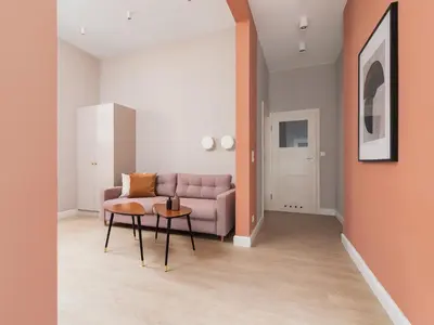 a living room with a pink couch and a table at Main square - Apartment with 2 bedrooms in Kraków