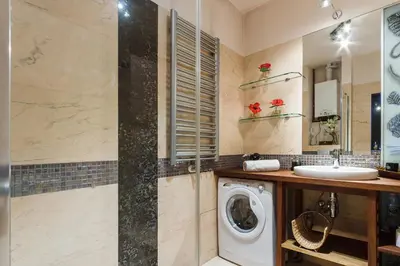 a bathroom with a washing machine and a sink at Luxury Apartment - Kazimierz District in Kraków