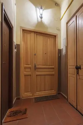 a hallway with wooden doors and a light on the ceiling at Luxury Apartment - Kazimierz District in Kraków