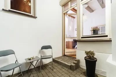 a room with two chairs and a table and a window at Luxury Apartment - Kazimierz District in Kraków