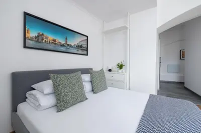 a bedroom with a white bed with a tv on the wall at Zyblikiewicza 5- Studio Apartment- Old Town in Kraków