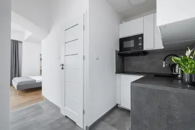 a kitchen with white cabinets and a microwave at Zyblikiewicza 5- Studio Apartment- Old Town in Kraków