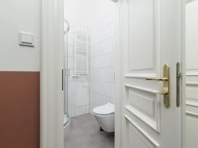 a white bathroom with a toilet and a glass door at Apartment with balcony - Rejtana 10 in Kraków