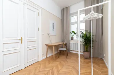 a hallway with a white door and a wooden table at Apartment with balcony - Rejtana 10 in Kraków