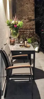 a table with a vase of flowers and a chair at Apartament w sercu Krakowa in Kraków