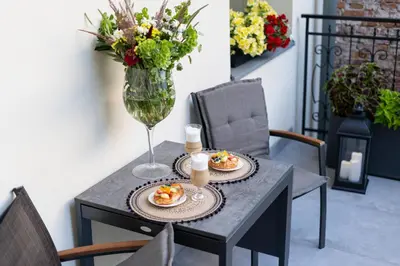 a table with two plates of food and a vase with flowers at Apartament w sercu Krakowa in Kraków