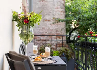 a table with plates of food and a vase of flowers at Apartament w sercu Krakowa in Kraków