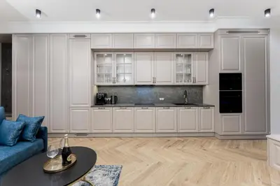 a kitchen with white cabinets and a blue couch at Apartament w sercu Krakowa in Kraków