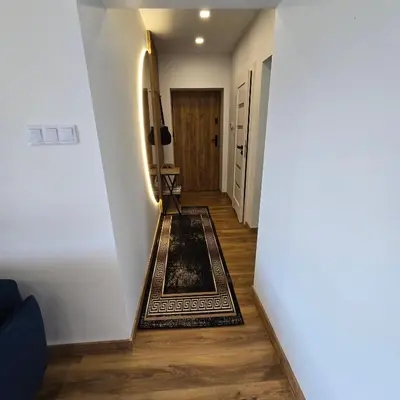 a hallway with a rug on the floor at Mieszkanie nad Jeziorem Rożnowskim in Rożnów