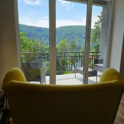 a living room with a view of a balcony at Mieszkanie nad Jeziorem Rożnowskim in Rożnów