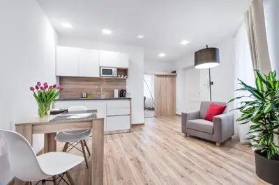 a kitchen and living room with a table and chairs at Old Town Apartments - B12 in Kraków